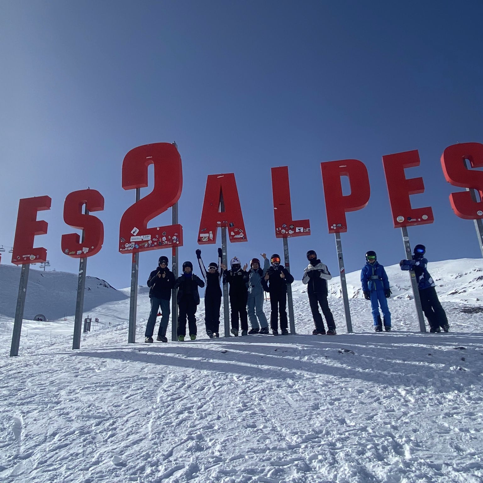 Group photograph on the slopes, underneath red letters sign