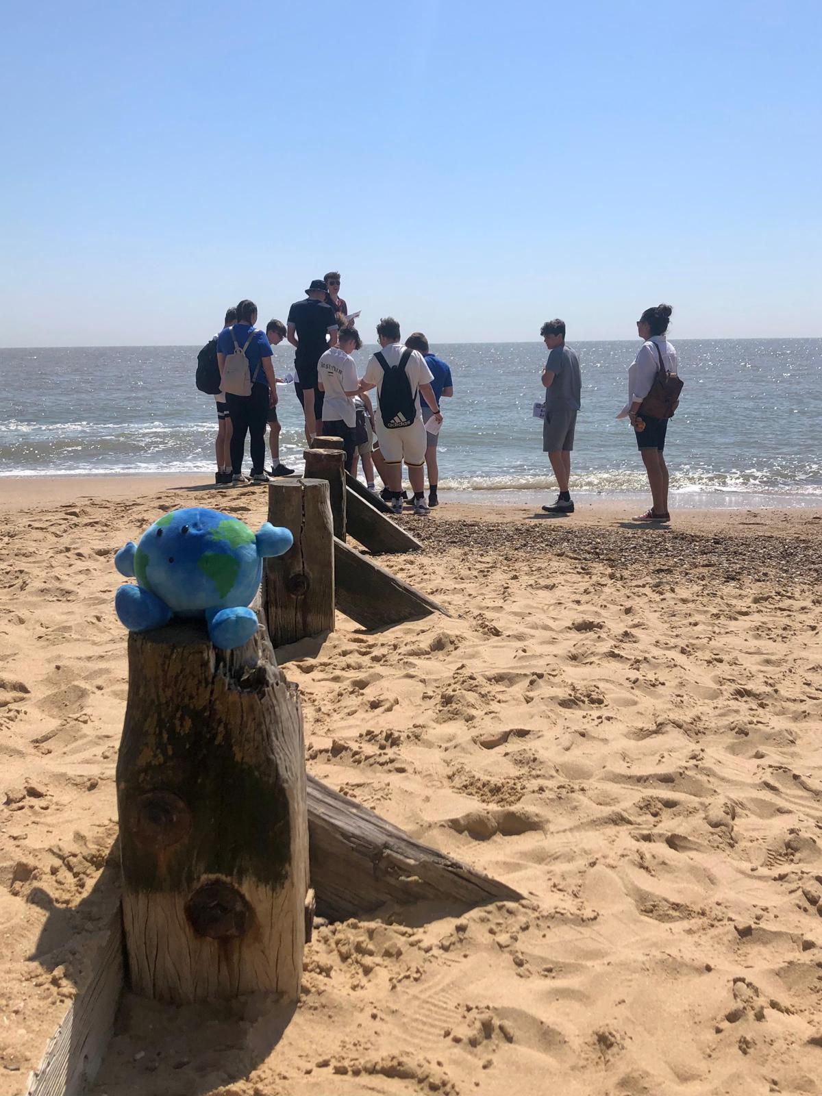 GCSE Geography students  on the beach measuring sea groynes 